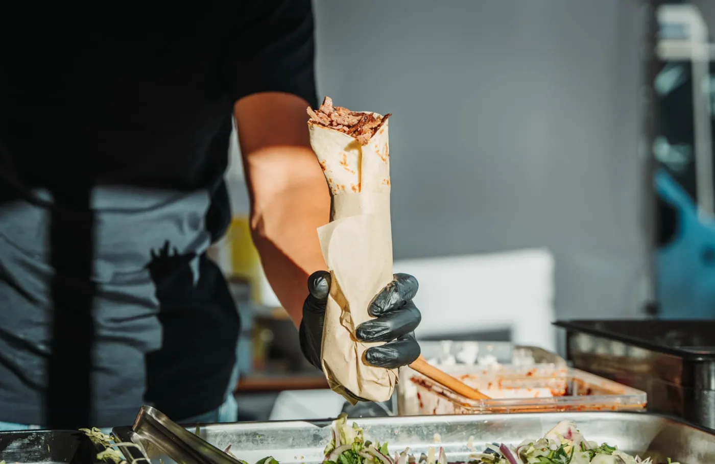 Kok i kebab foodtruck samler en kebabrulle til en gæst