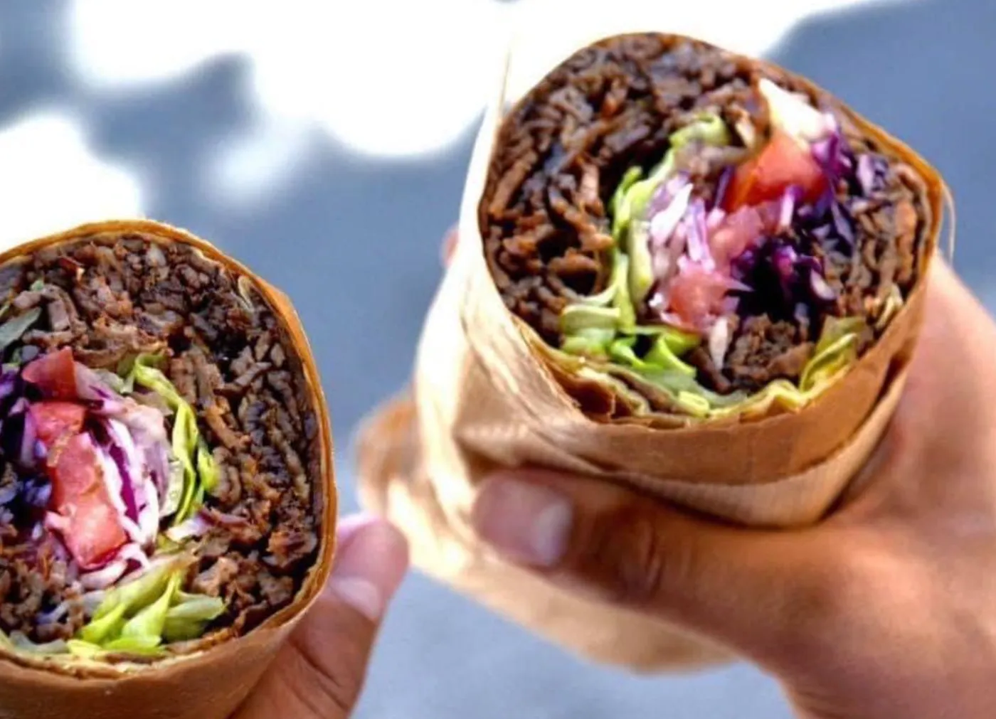 To gæster holder hver sin kebabrulle ved en havefest nær Helsingør